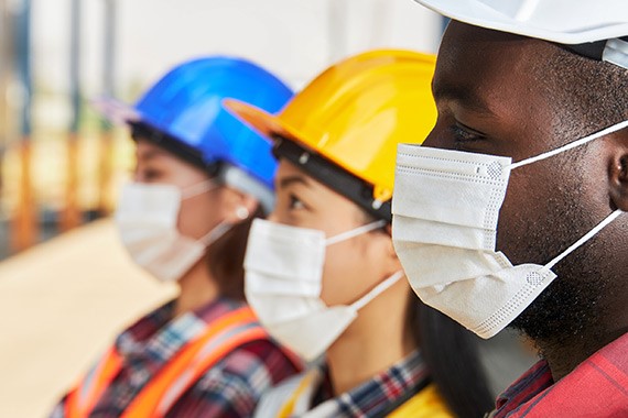 Headshot of three construction workers wearing masks as a health measure in the prevention of COVID-19.