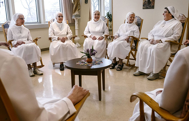 Nuns from the community of Augustines nestle together and talk in a common room at Le Monastère.