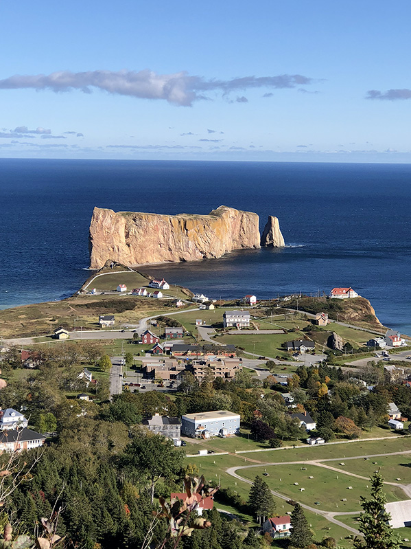 An aerial view of the town of Percé and the Rocher Percé taken from the paths leading to the suspended platform of the Géoparc mondial UNESCO