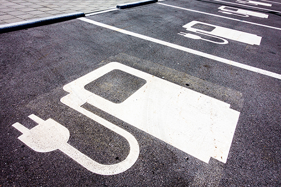 Asphalt parking spaces for electric cars, identified by a pictogram painted on the ground and representing an electric charging station.