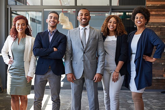 Young Black businesspeople posing together, all smiles.