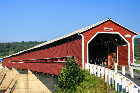 The Perreault bridge, a red covered bridge built in 1928 over the Chaudière river in the Beauce region.