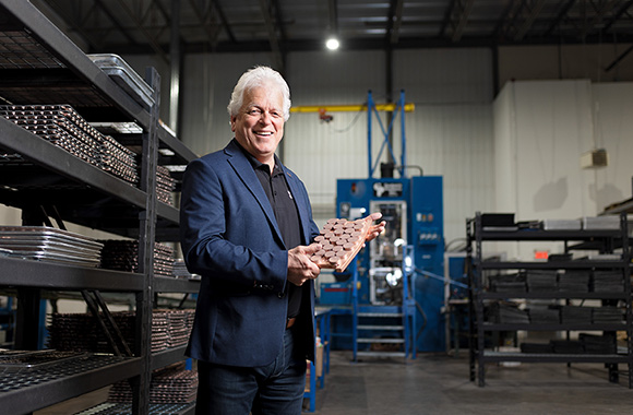 Christian Babin, founder of Kuma Brakes, stands in the center of the warehouse and holds a wind turbine brake pad in his hands.